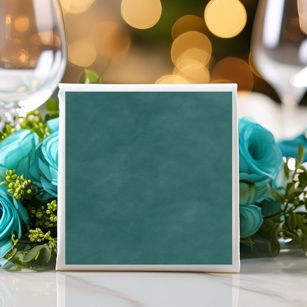 Simple dark teal watercolor wedding napkins on a table with teal roses and wine glasses.